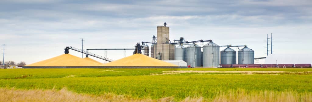 Corn harvest in the fall in the mid-west of USA. The harvesting and processing of the corn crop, the processing facilities doing finishing work on the grain, the product are stored in the grain silos or is shipping out in train cars. Photographed in panoramic horizontal format on location in Minnesota, USA.