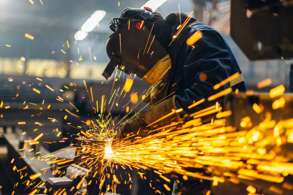 Metal worker using a grinder