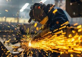 Metal worker using a grinder